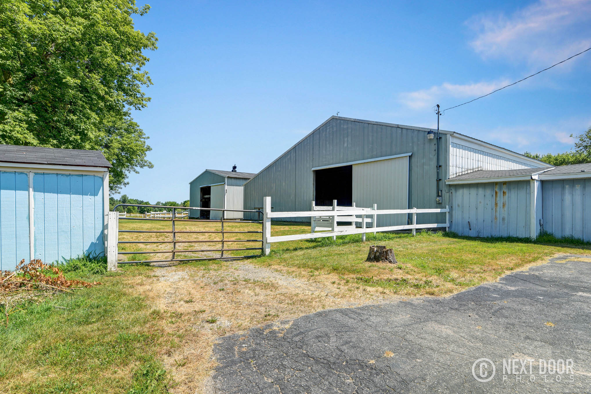 Barns, gates, and fenced grounds at a Lansing horse boarding property